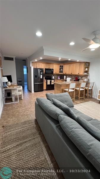 a living room with furniture and a view of kitchen