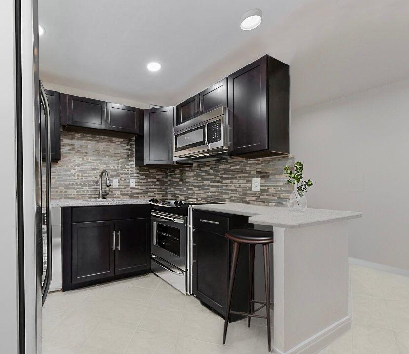 a kitchen with stainless steel appliances granite countertop a sink stove and microwave