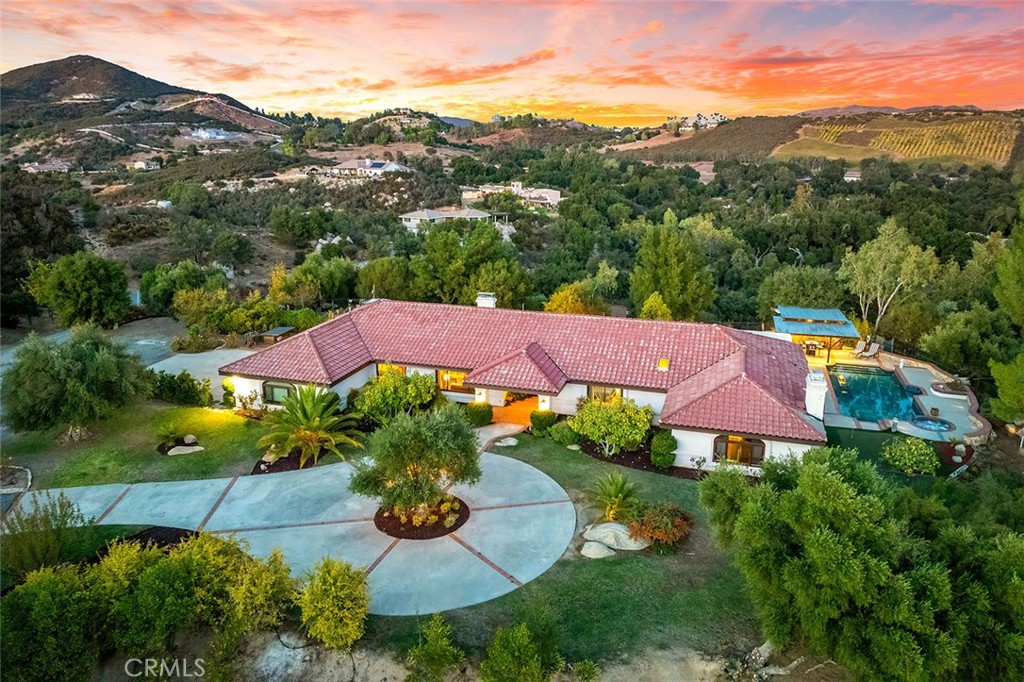 an aerial view of residential houses with outdoor space and trees