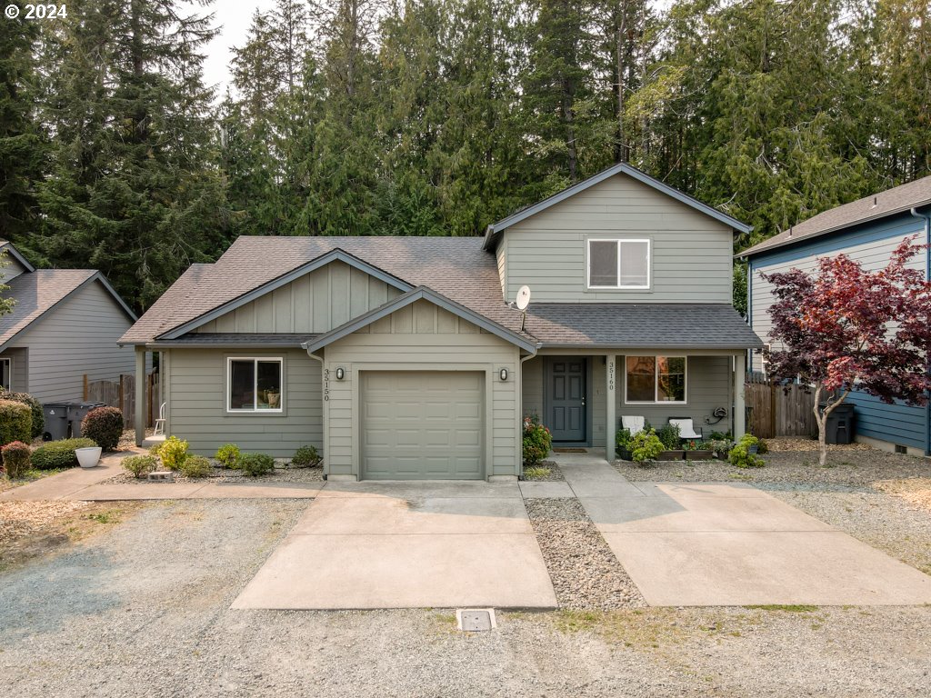 a front view of a house with a yard and trees