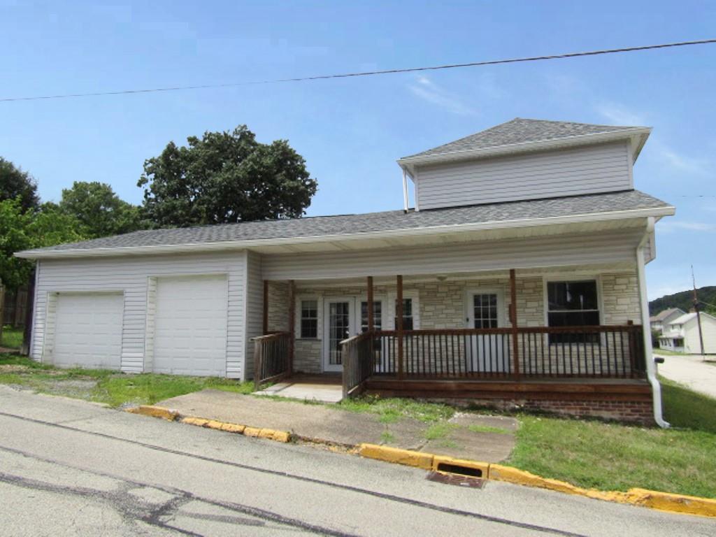 a view of a house with a patio and a yard