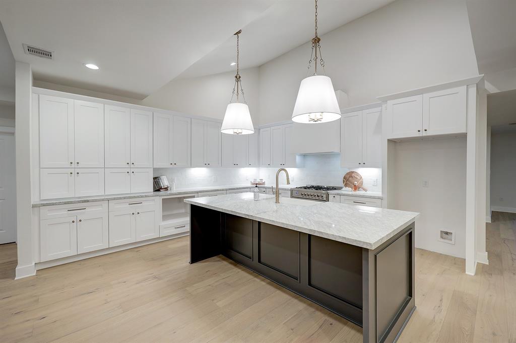 a kitchen with kitchen island granite countertop a sink cabinets and stainless steel appliances