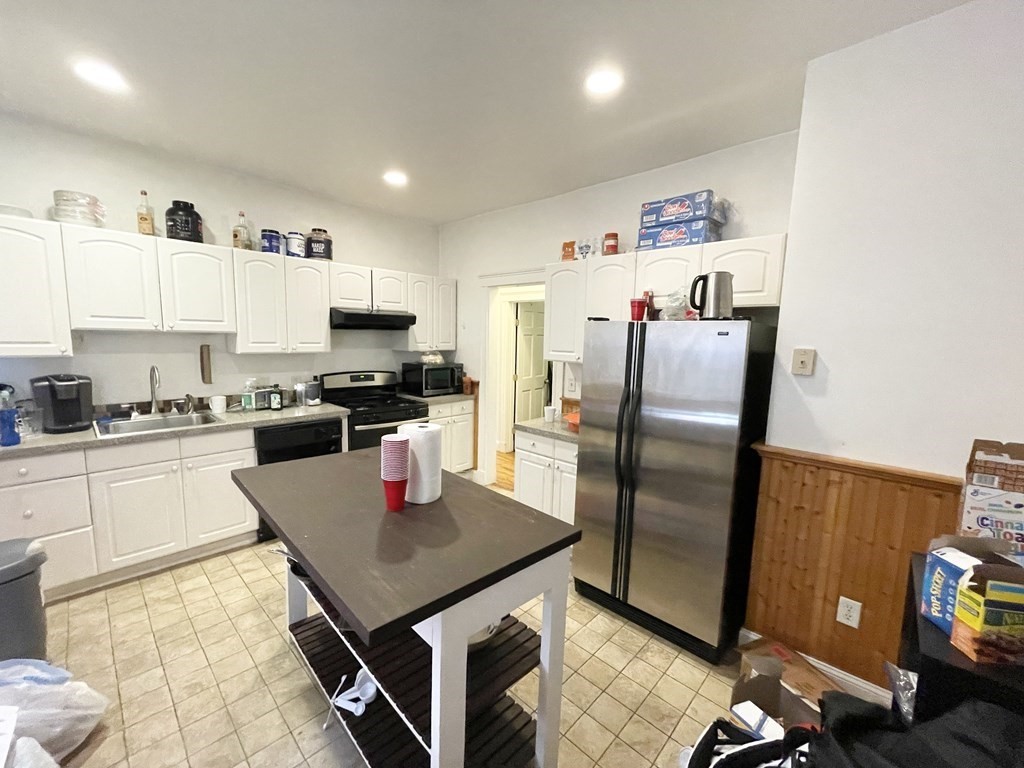 a kitchen with stainless steel appliances granite countertop a refrigerator and a stove top oven