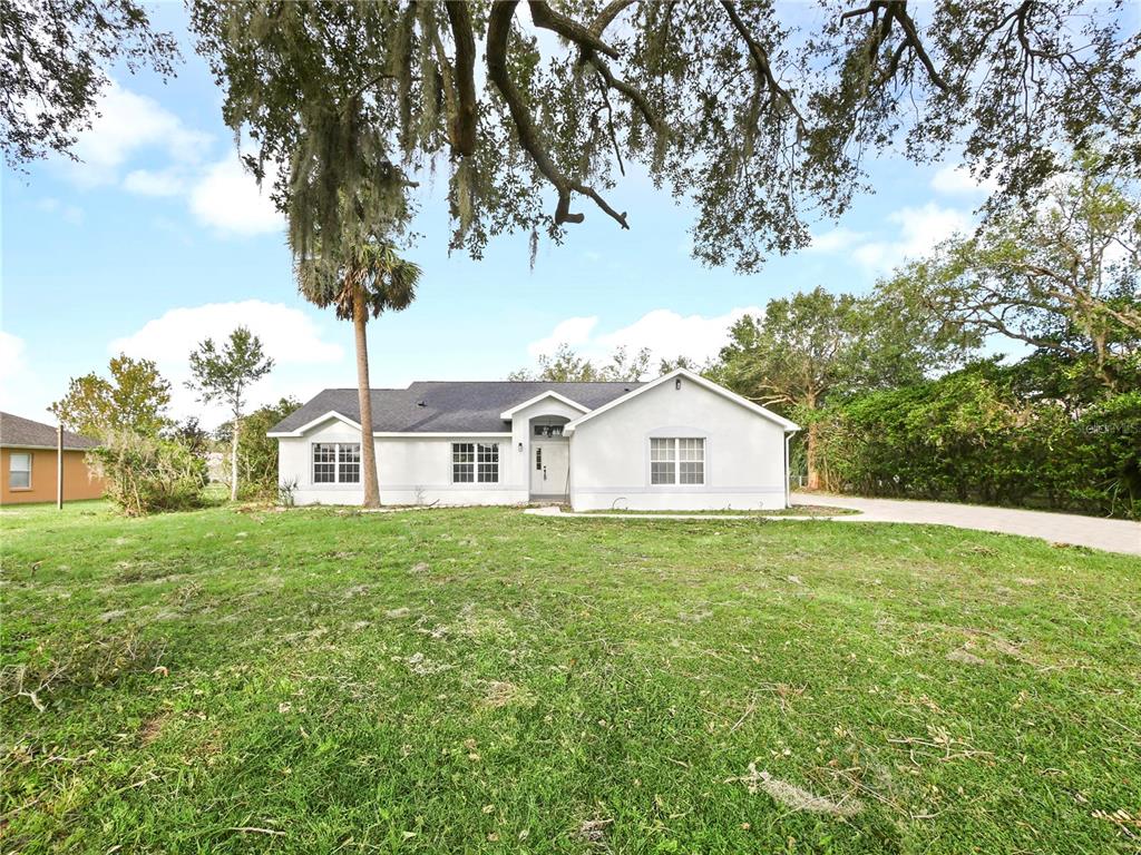 a front view of a house with yard and green space