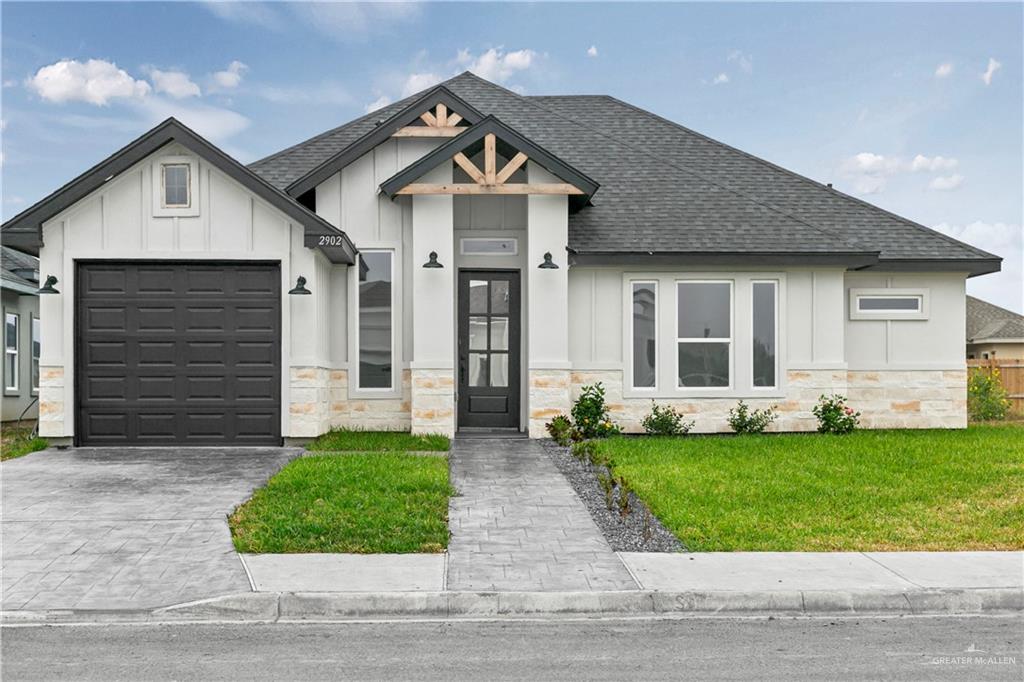 Modern farmhouse style home featuring a front lawn and a garage