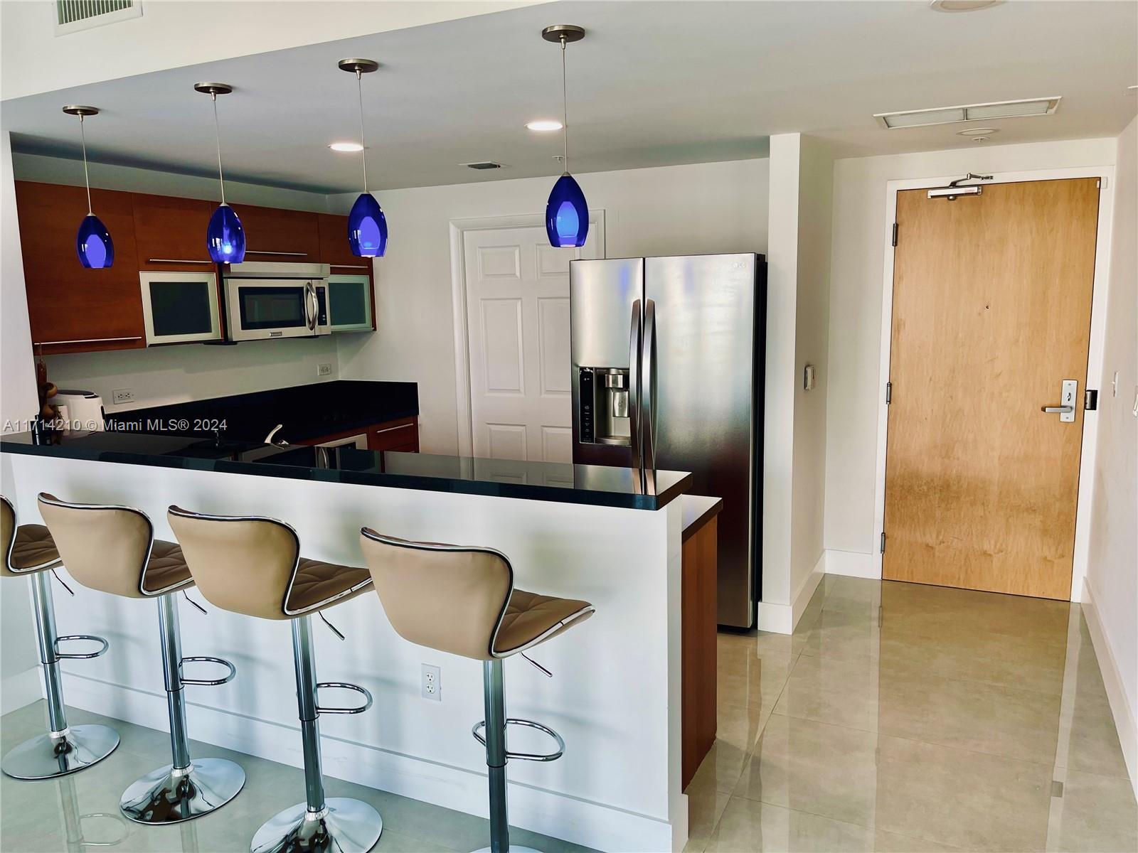 a kitchen with stainless steel appliances granite countertop a refrigerator and a stove top oven