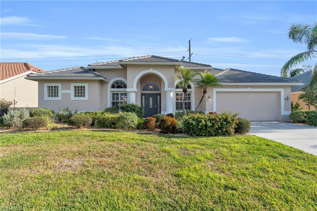 View of front of property featuring a garage and a front yard