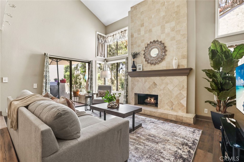 a living room with furniture a fireplace and a potted plant