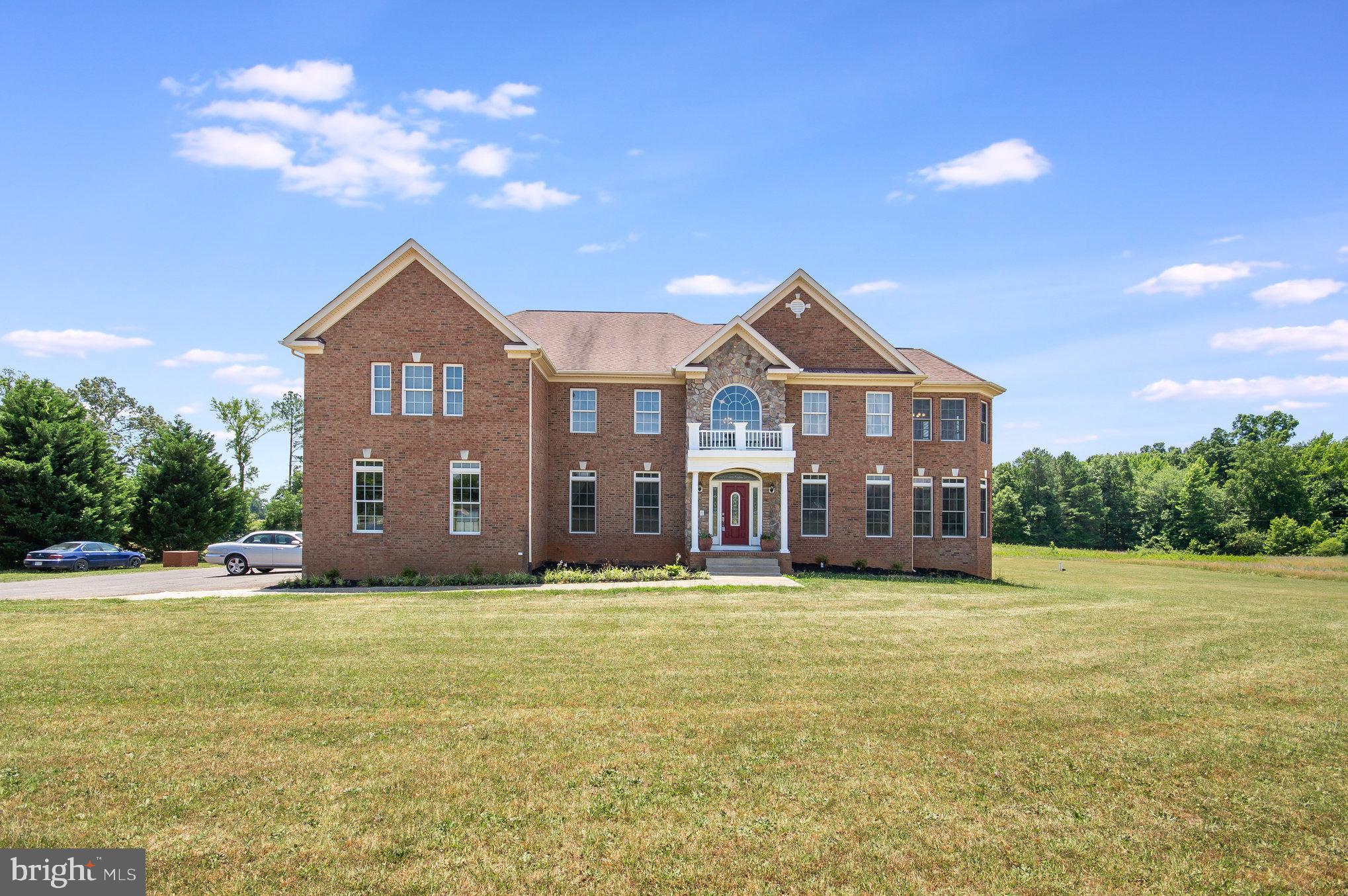 a view of a house with a big yard and large trees