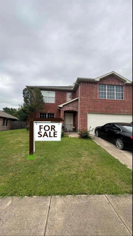 View of front of home featuring a garage and a front lawn