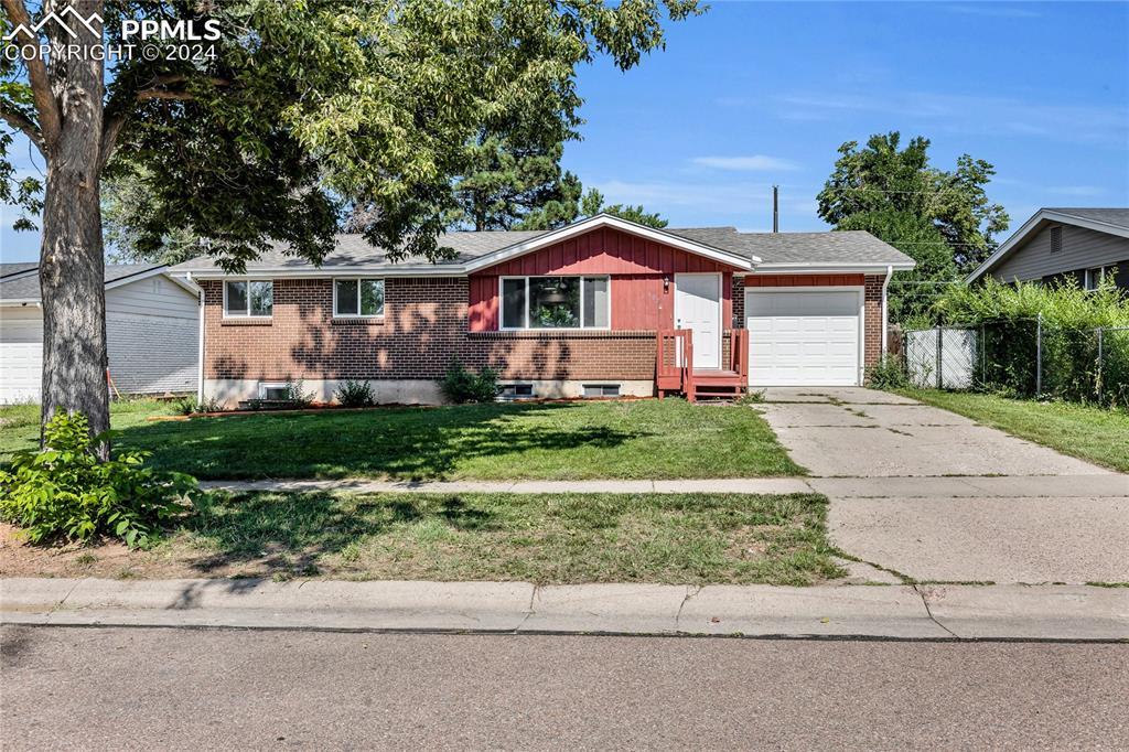 Ranch-style house with a garage and a front yard