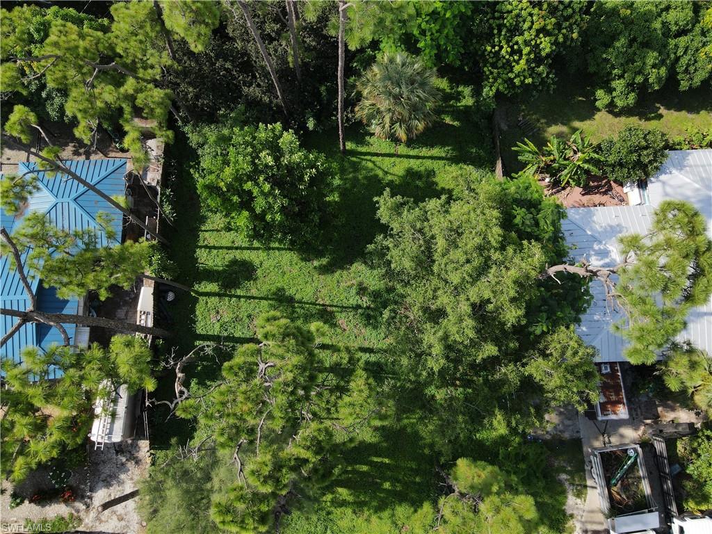 an aerial view of residential house with outdoor space and trees all around