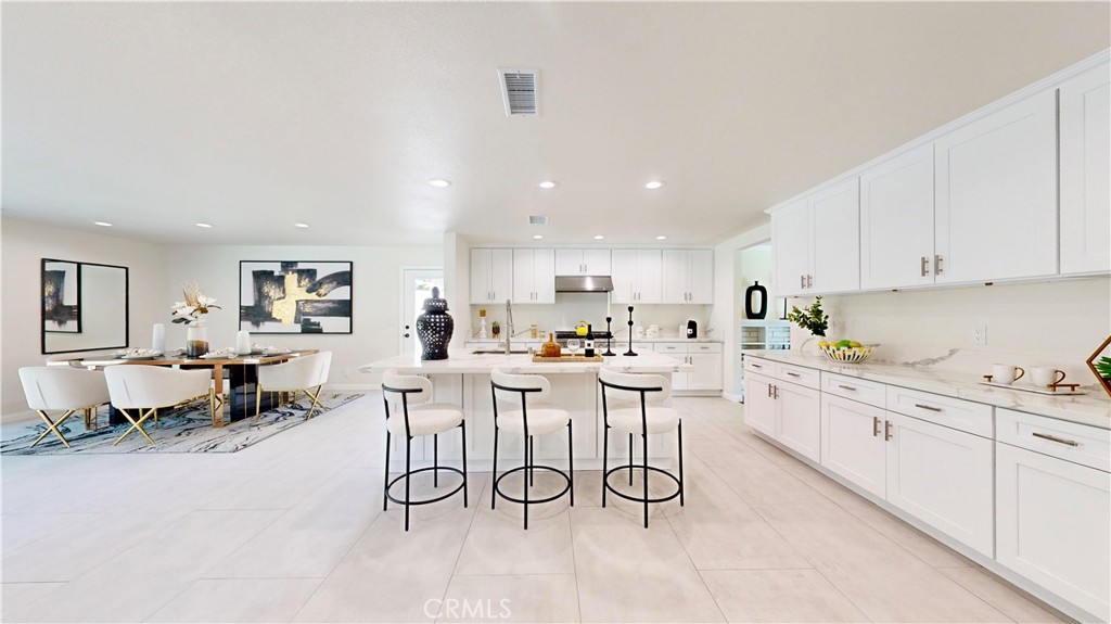 a large white kitchen with lots of counter space a sink and appliances