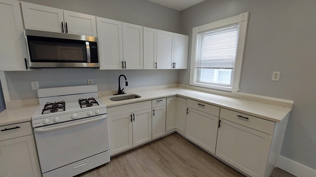 a kitchen with appliances a sink and a window