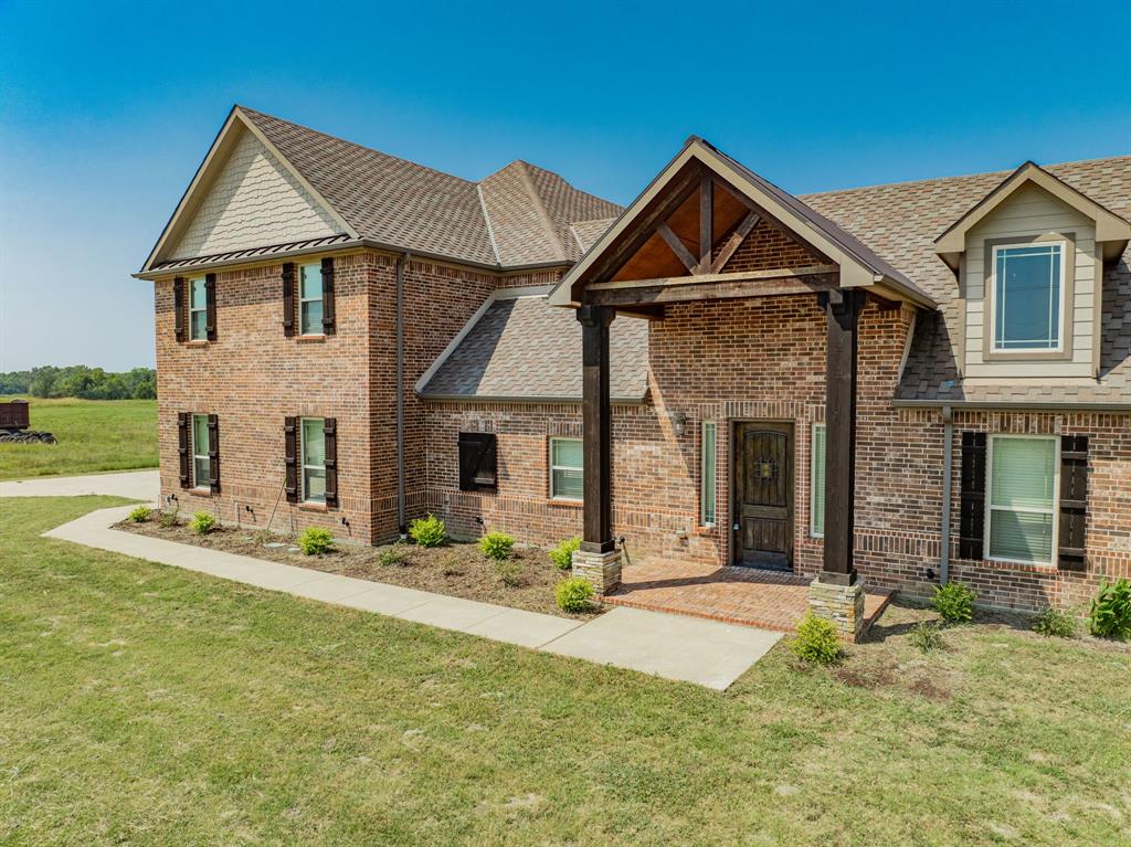 a front view of a house with yard and parking