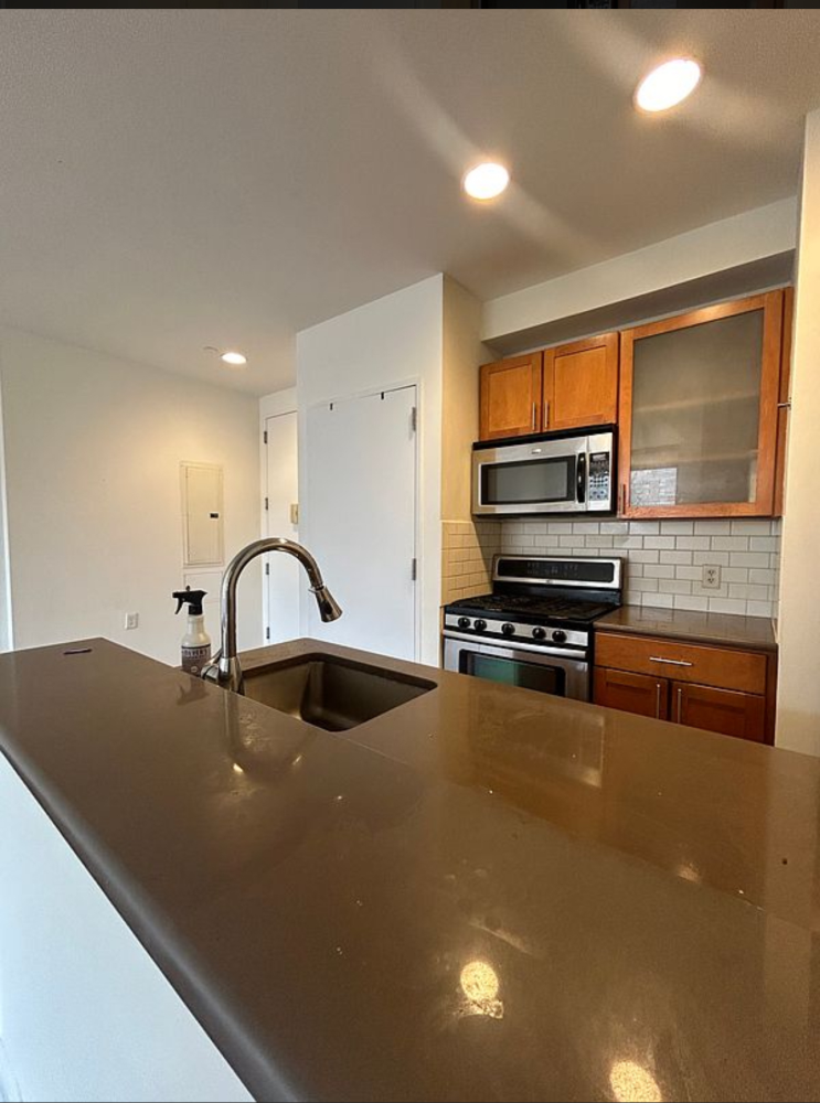 a kitchen with stainless steel appliances a sink a stove and cabinets