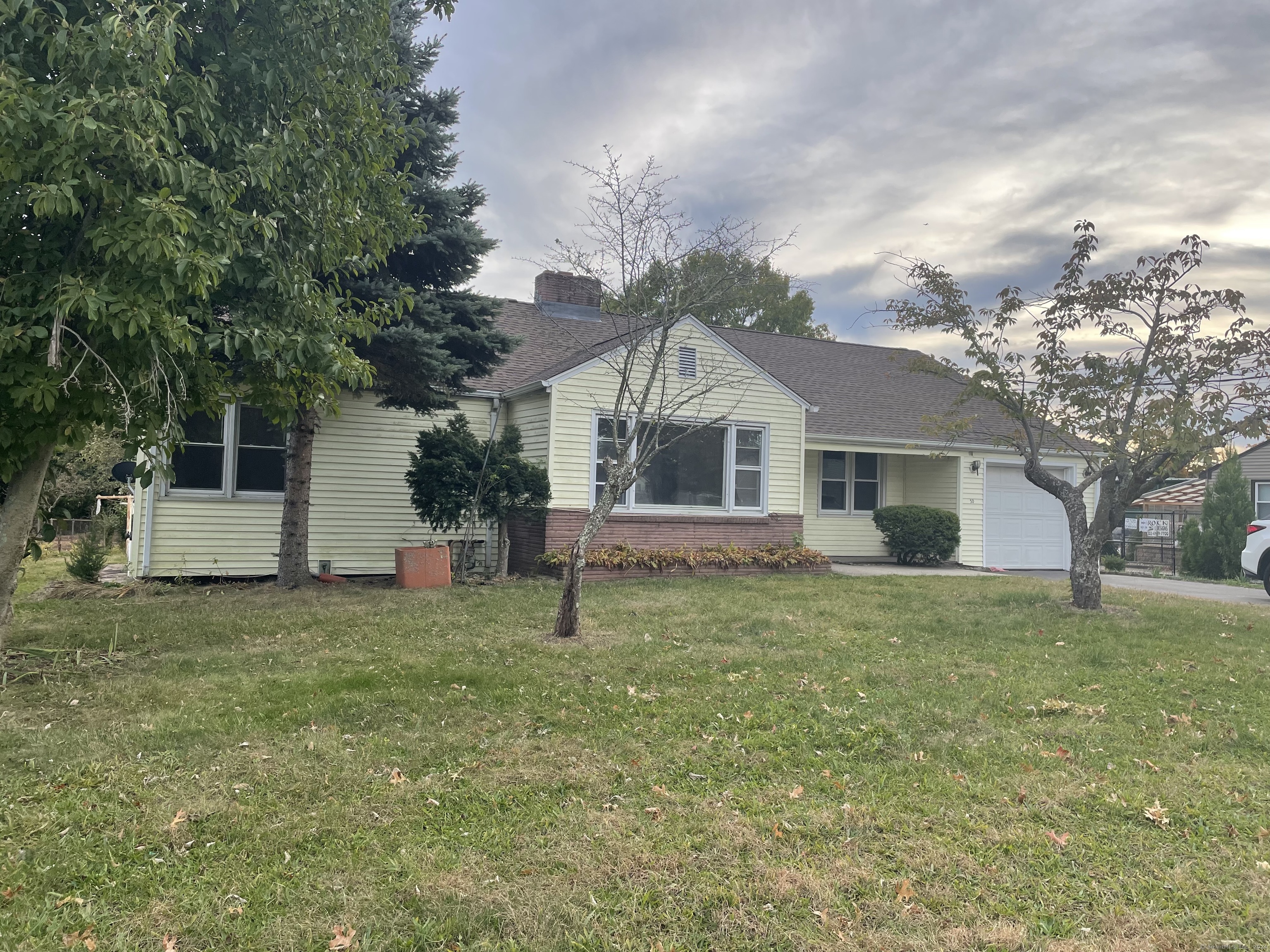 a front view of house with yard and trees