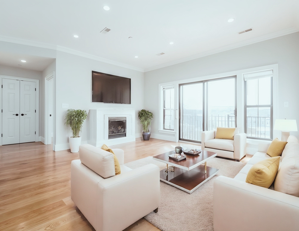 a living room with furniture fireplace and a large window