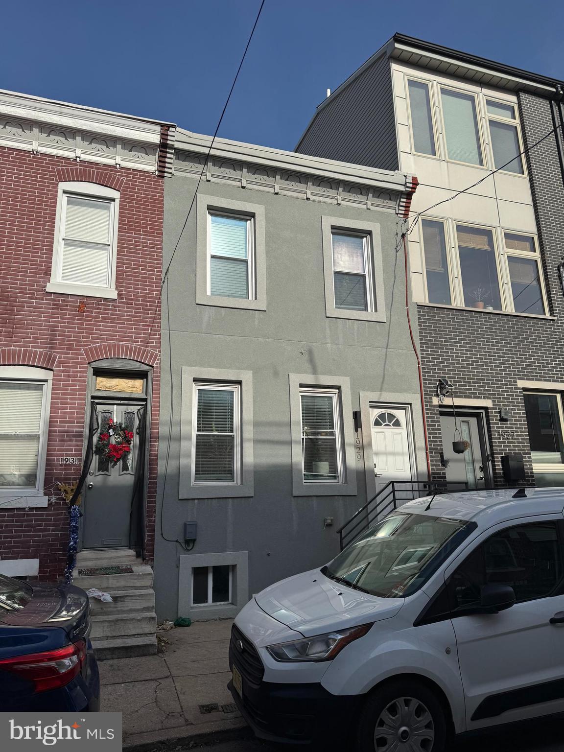 a front view of a house with car parked