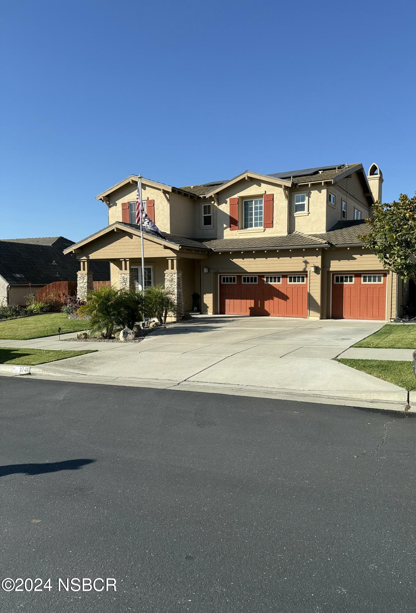 a front view of a house with a garden and plants