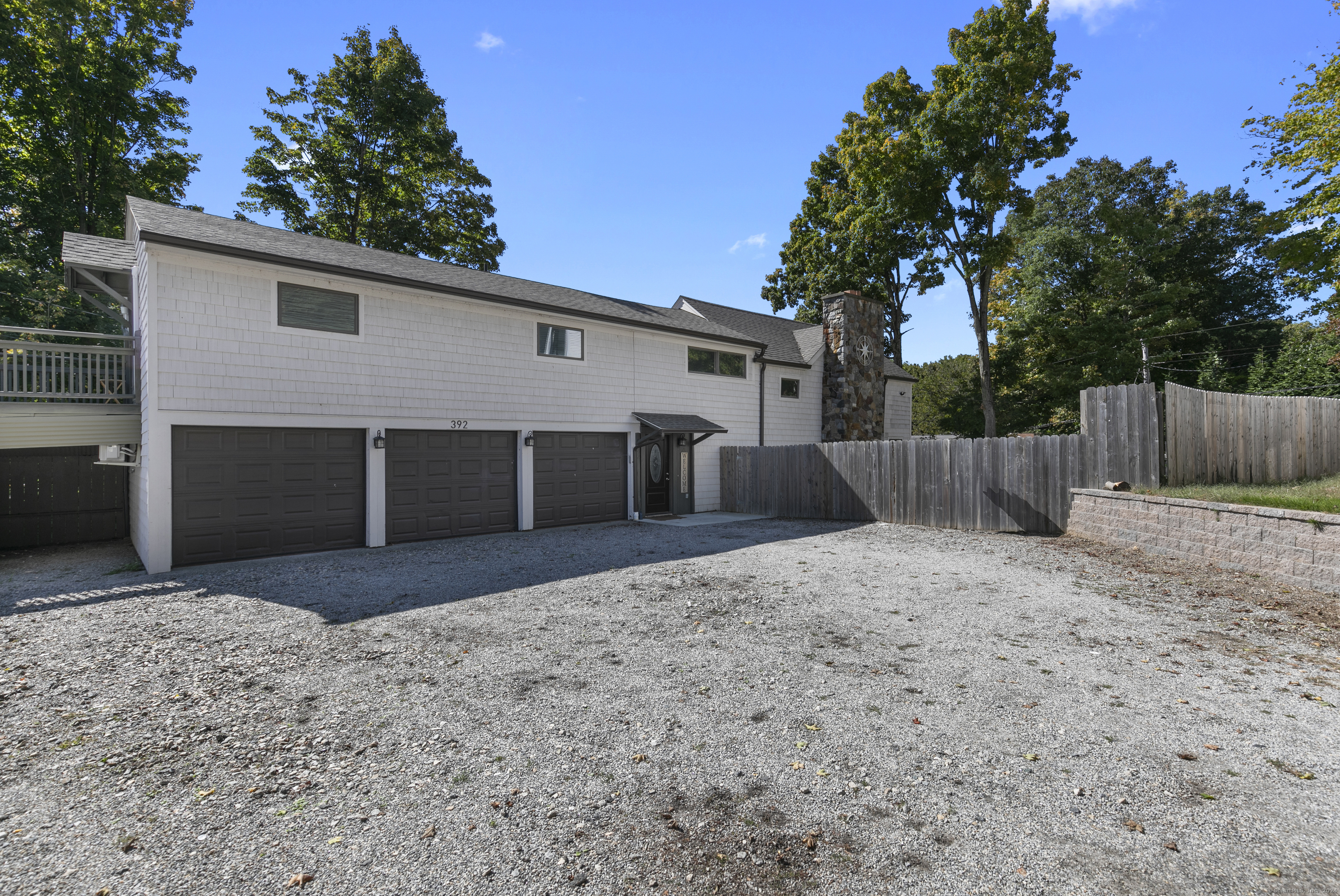 a front view of house with yard and trees in the background