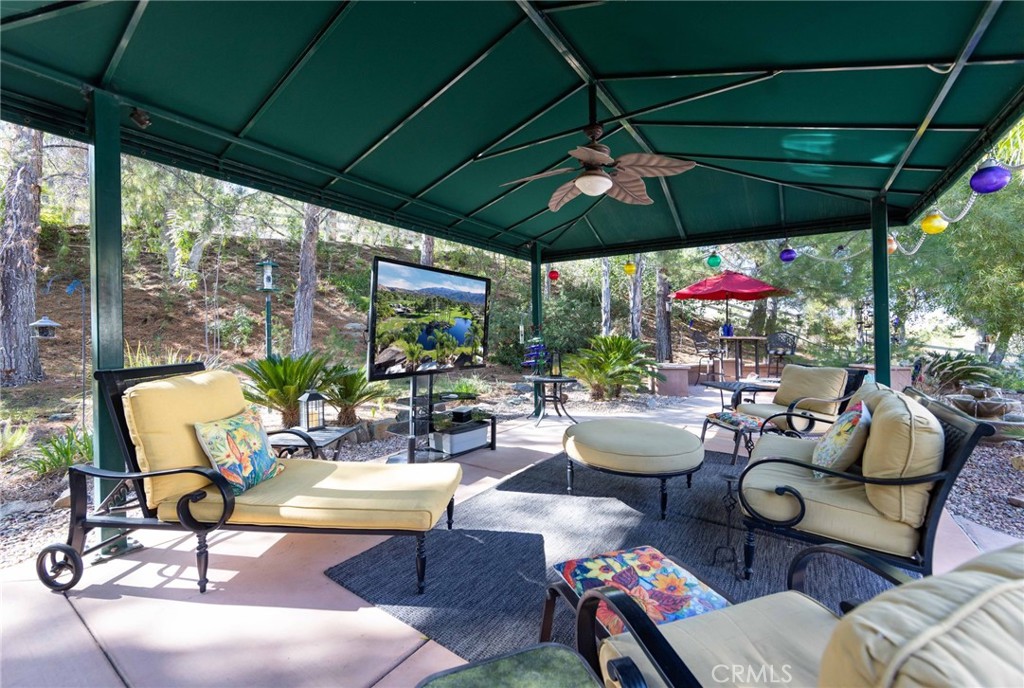 a view of patio with chairs and tables under an umbrella