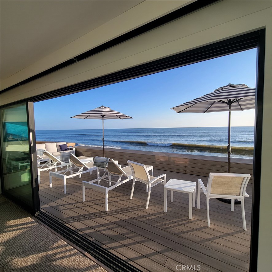 a view of a balcony with chairs and wooden floor