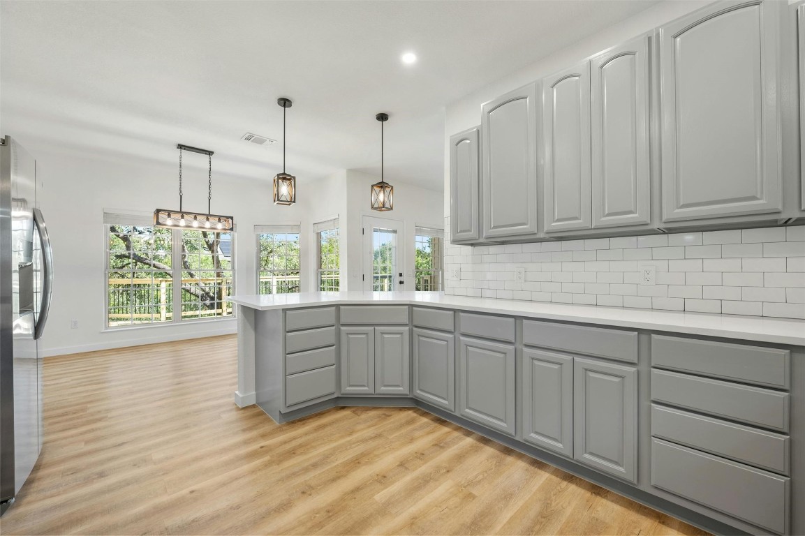 a kitchen with stainless steel appliances granite countertop a stove a sink and white cabinets with wooden floor