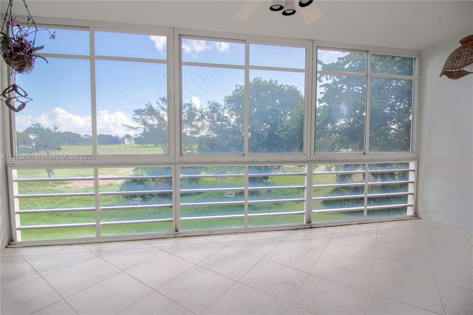 a view of a room with a large window and wooden floor