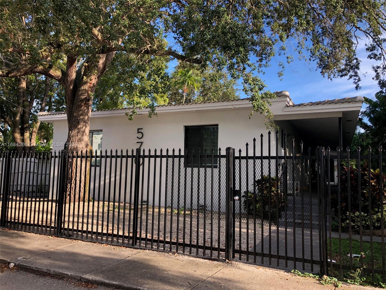 a view of a house with a small yard and wooden fence