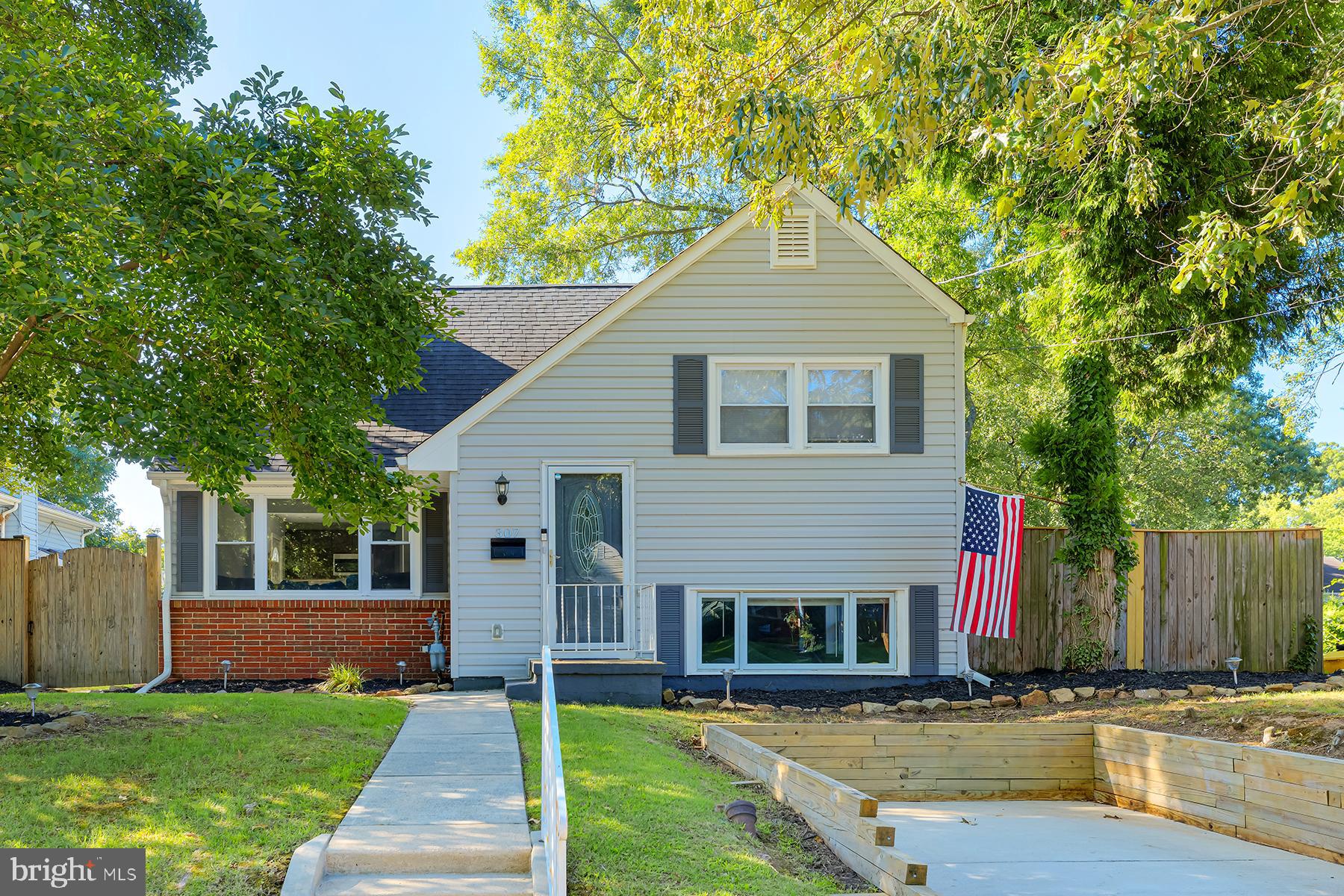 a front view of house with yard and trees in the background