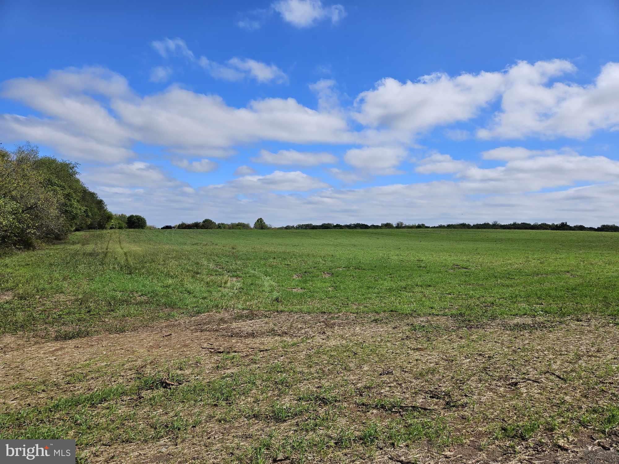 a view of a field with an ocean and in background