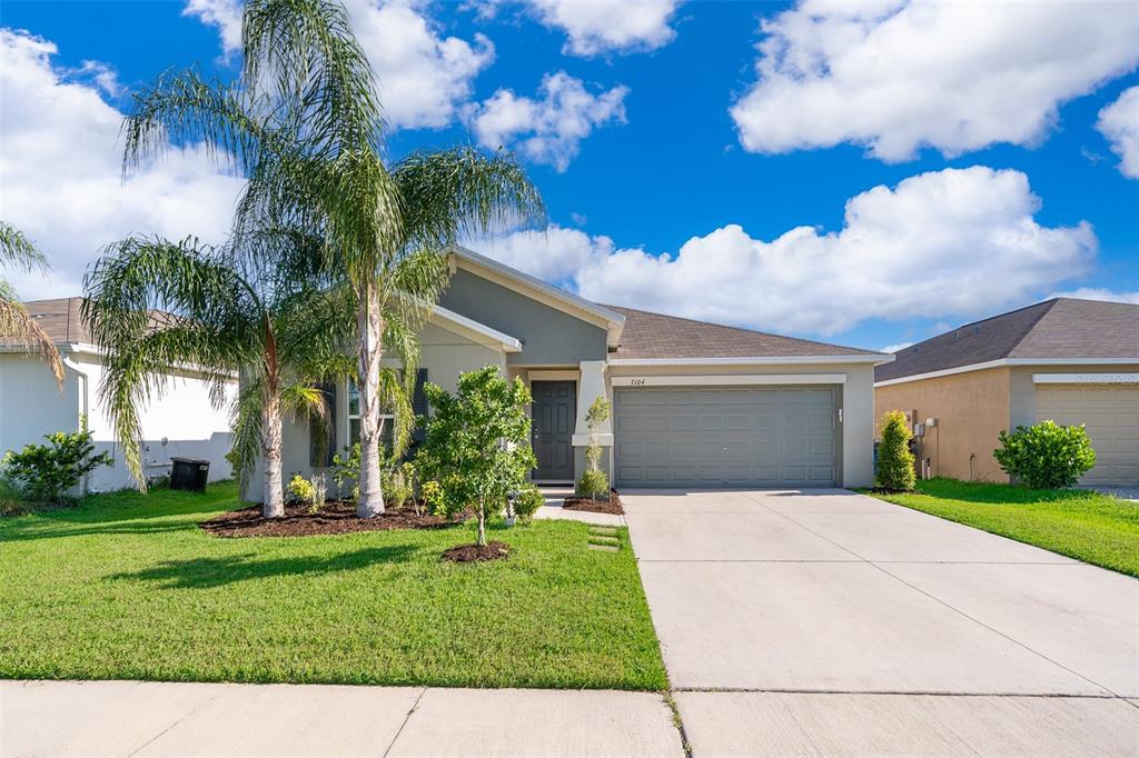 a front view of a house with a garden and yard