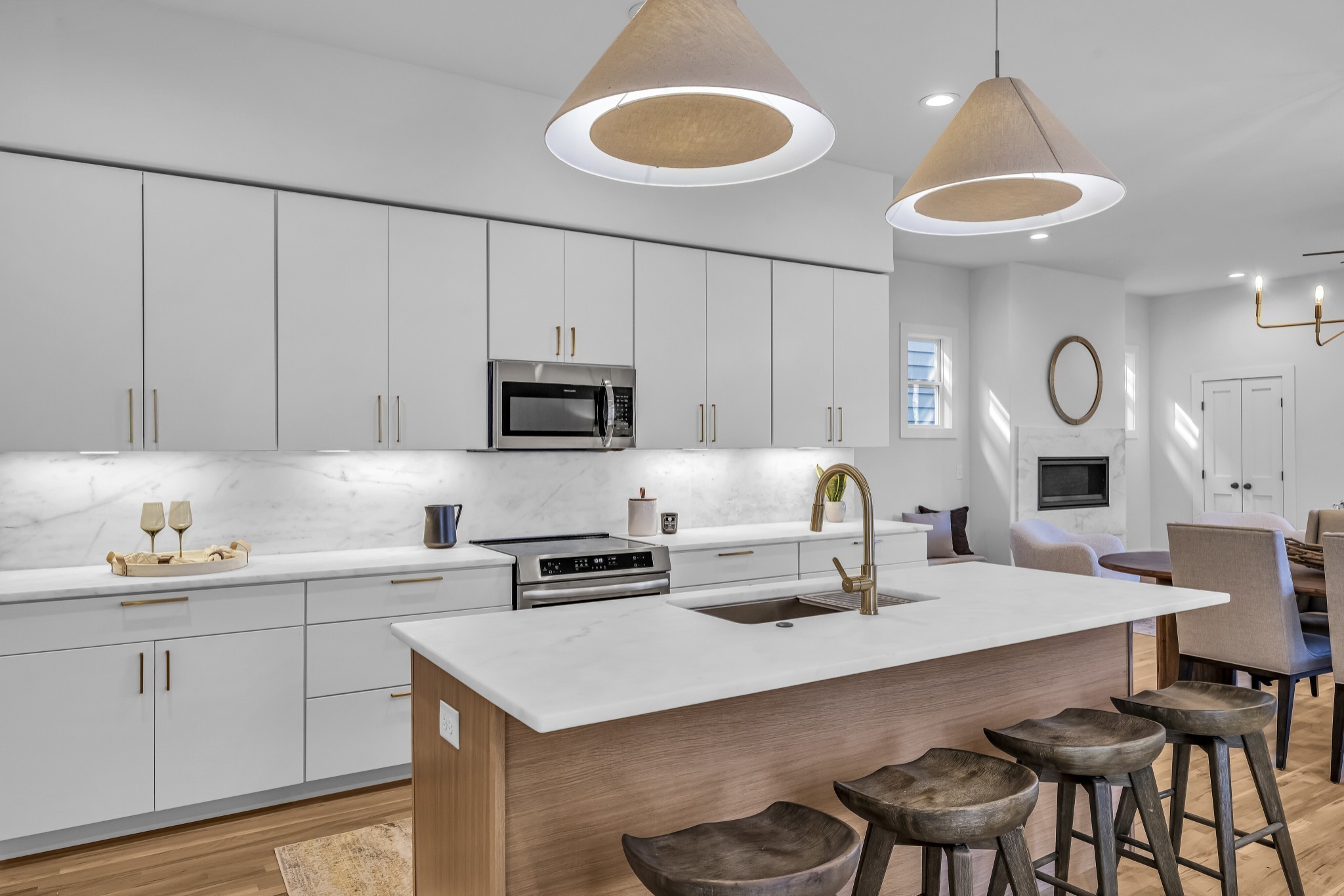 a kitchen with stainless steel appliances a sink a stove a table and chairs