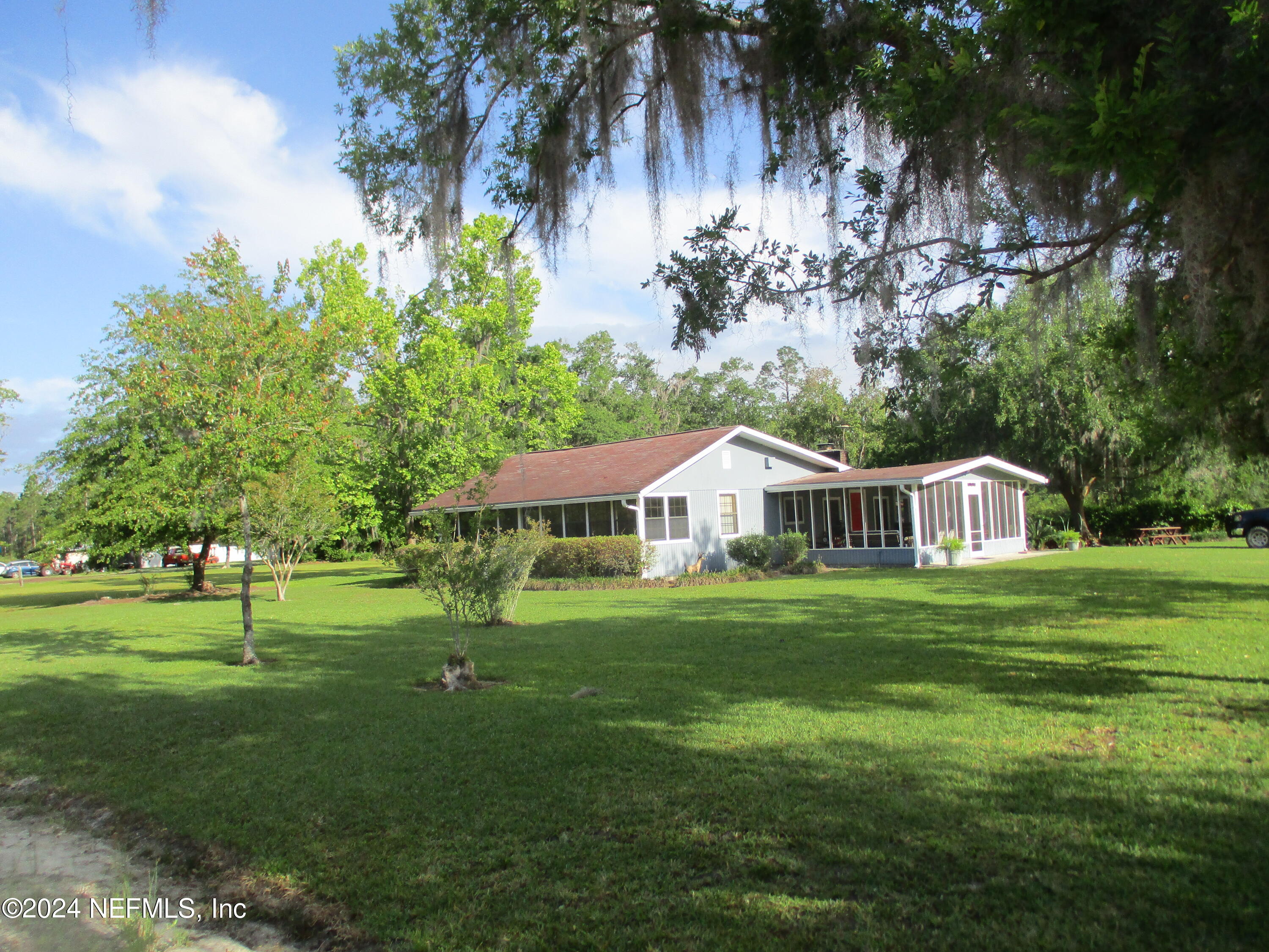 a front view of a house with a yard and trees