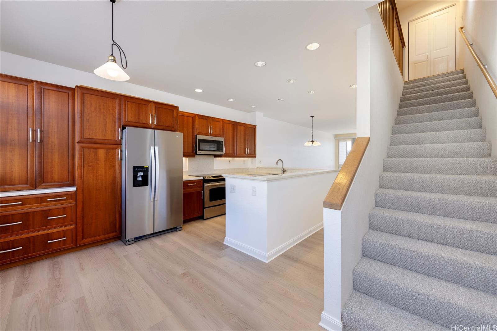 a view of a kitchen with refrigerator and wooden floor