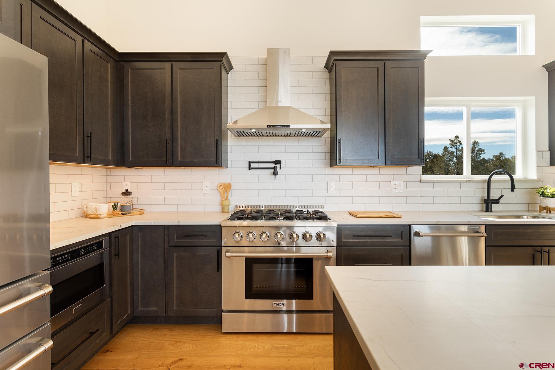 a kitchen with stainless steel appliances granite countertop a stove a sink and a refrigerator