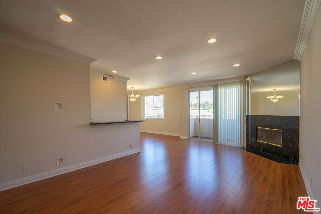 a view of an empty room with a fireplace and a window