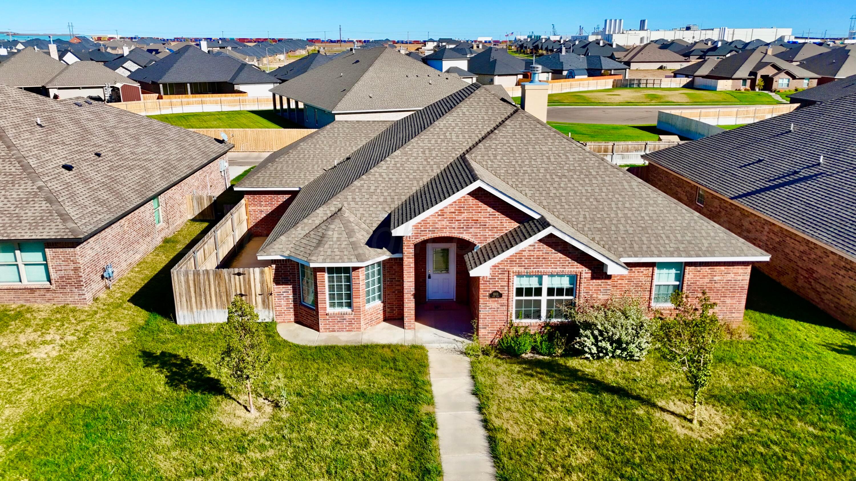 an aerial view of a house with swimming pool and yard