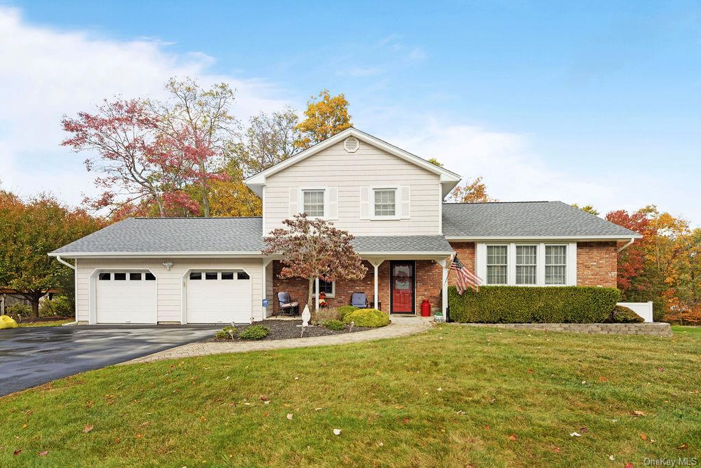 View of front of house featuring a front lawn and a garage