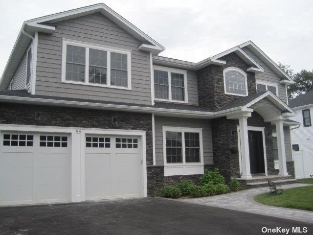 a front view of a house with yard and parking