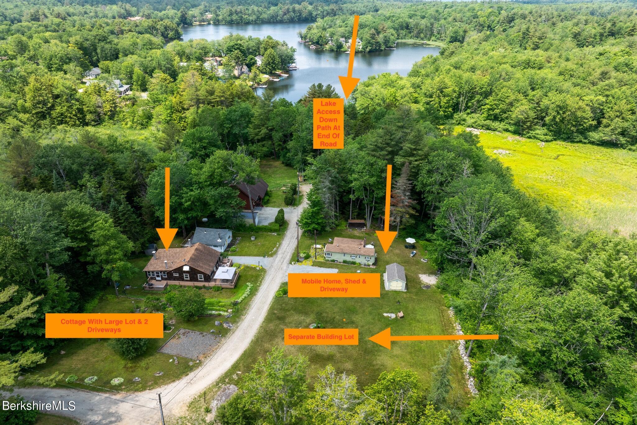 an aerial view of a house with swimming pool a yard and lake view