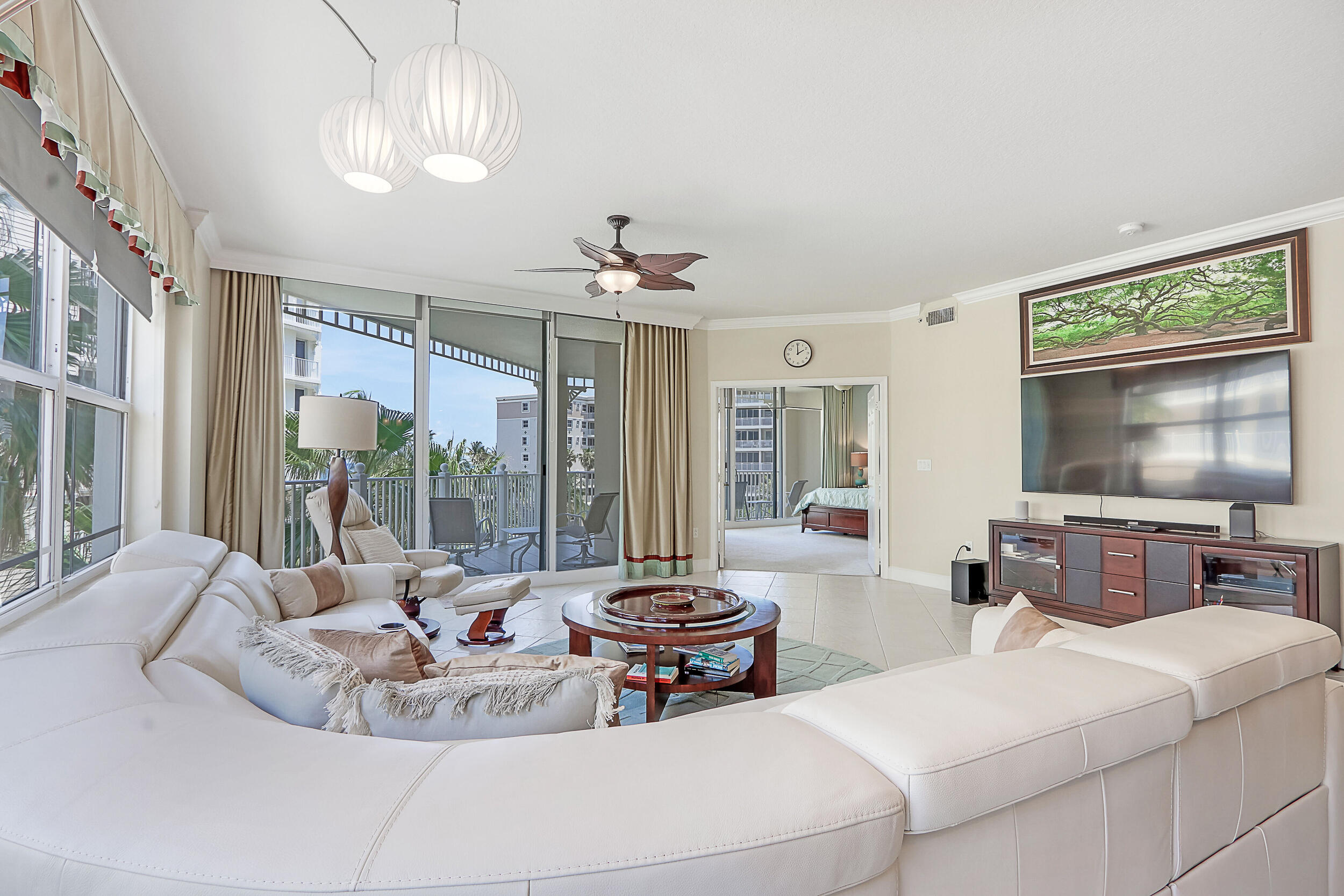 a living room with furniture a flat screen tv and a large window