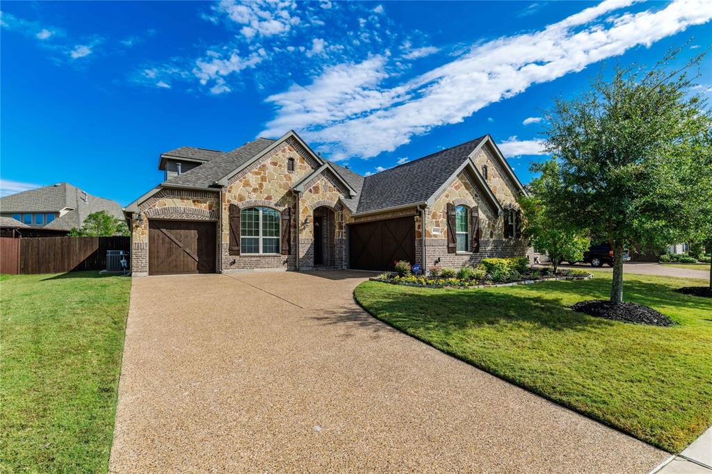 View of front facade with a garage, cooling unit, and a front lawn