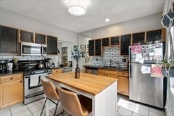 a kitchen with stainless steel appliances granite countertop a sink a stove and a refrigerator