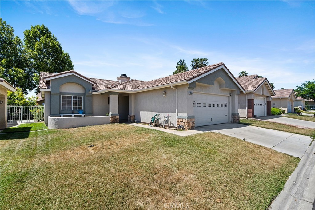 a view of a house with a yard and large tree