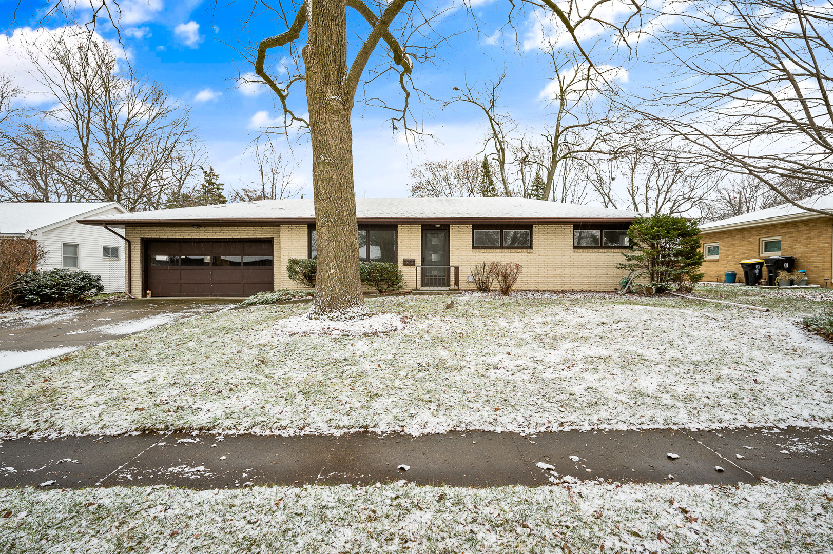 a view of a white house with a yard covered in snow