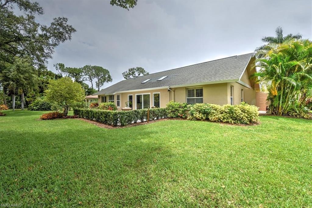 Back yard of property featuring a spacious lawn and patio