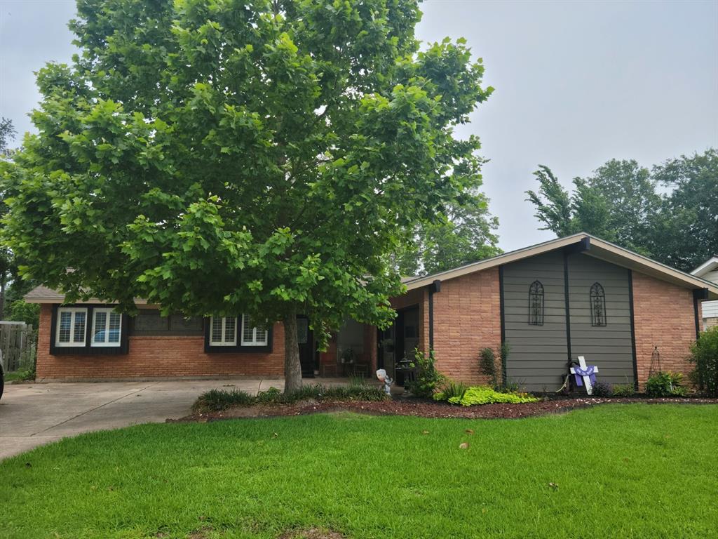 a front view of a house with a garden and trees