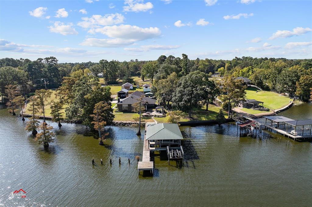 an aerial view of a house with swimming pool and lake view